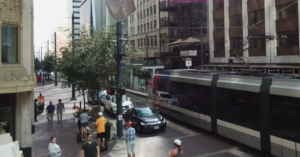 busy street in America with people, cars and a tram